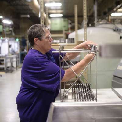 Employee in warehouse working on frame system.