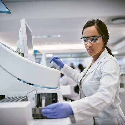 woman in protective equipment working with centrifuge