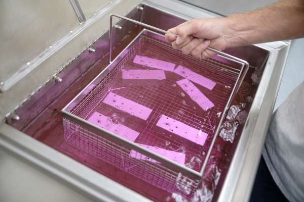 parts being dipped in cleaning solution